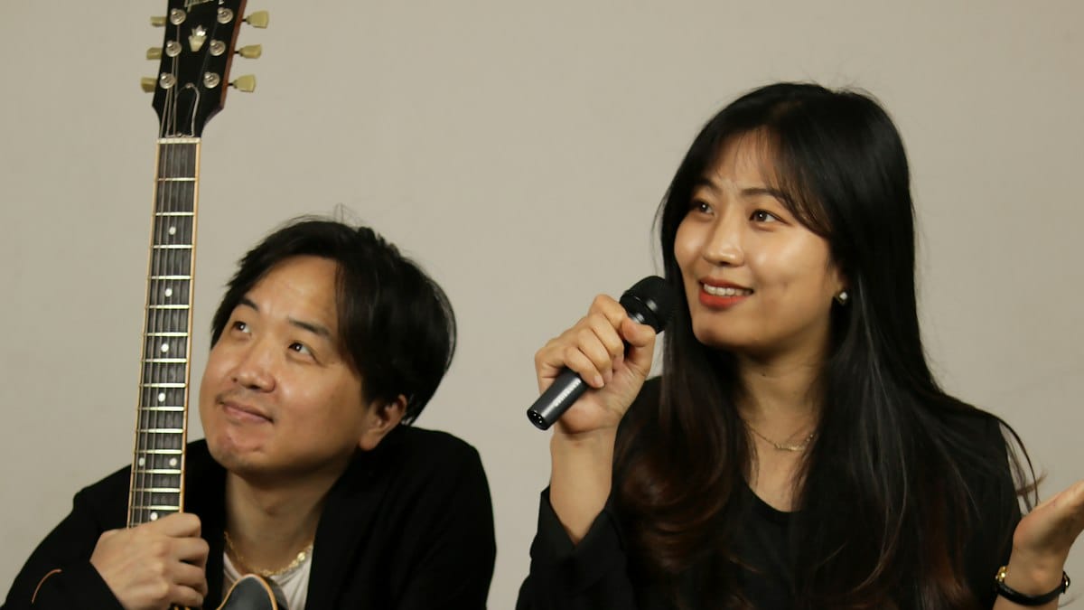 기타를 연주하는 사람과 마이크로 노래하는 사람